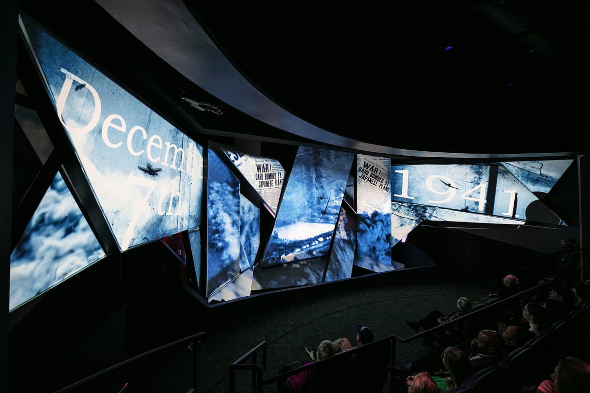 Freedom Theater faceted multi-surface projection screens showing December 7th 1941 content to a seated audience at The National WWII Museum