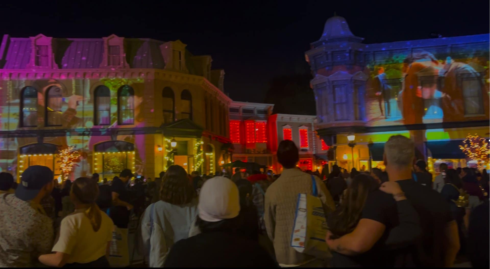 Holidays Made Here projection mapping across Warner Bros. Studio Tour backlot facades with an audience watching at night